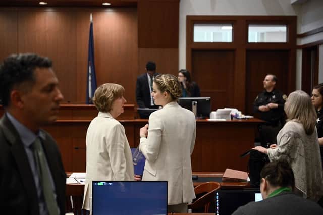 Amber Heard talking to her attorney in the courtroom (Photo by BRENDAN SMIALOWSKI/POOL/AFP via Getty Images)
