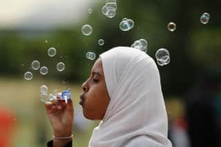 Девушка пускает мыльные пузыри во время празднования Ид в Берджесс-парке 28 июля 2014 года в Лондоне, Англия.