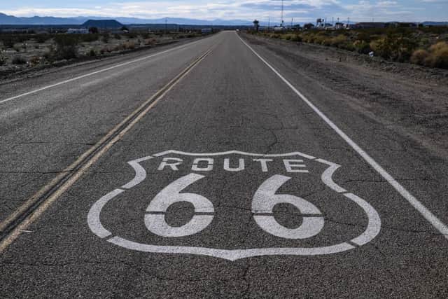 A “Route 66” sign is painted on the asphalt near Amboy in the Mojave Desert in California (Photo: ERIC BARADAT/AFP via Getty Images)