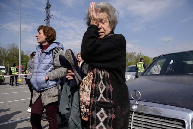 Mother and daughter Dina (R) and Natasha (L) from Mariupol react as they arrive in their own vehicle, separate from a larger convoy expected later, at a registration and processing area for internally displaced people arriving from Russian-occupied territories in Ukraine, in Zaporizhzhia on May 2, 2022, on the 68th day of the Russian invasion of Ukraine. - Ukrainian authorities are planning to evacuate more civilians from Mariupol on May 2, 2022, after dozens were finally brought to safety following weeks trapped under heavy fire in the strategic port city’s Azovstal steel complex. (Photo by Ed JONES / AFP)