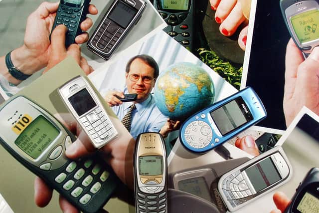 Nokia mobile telephones pictured 14 October 2004 with old photos of Nokia models, and a firm’s Chairman and Chief Executive Officer Jorma Ollilla (Photo: HEIKKI SAUKKOMAA/AFP via Getty Images)