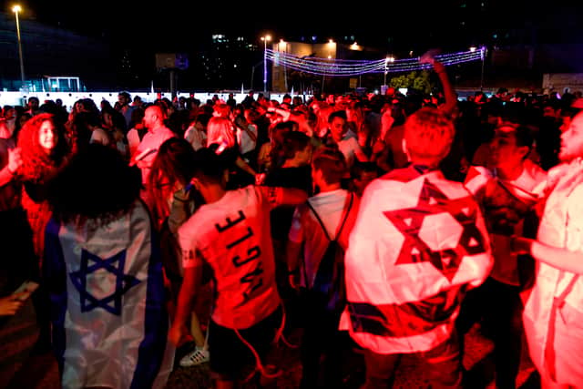Israeli youths draped in Israeli flags dance in a square in the centre of Jerusalem late on April 18, 2018, during the start of the 70th Independence Day celebrations.