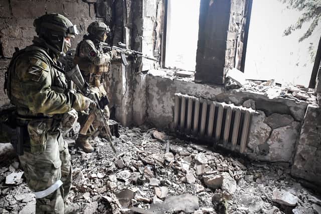 Two Russian soldiers patrol the Mariupol drama theatre, which was hit by a Russian strike in March. (Credit: Getty Images)