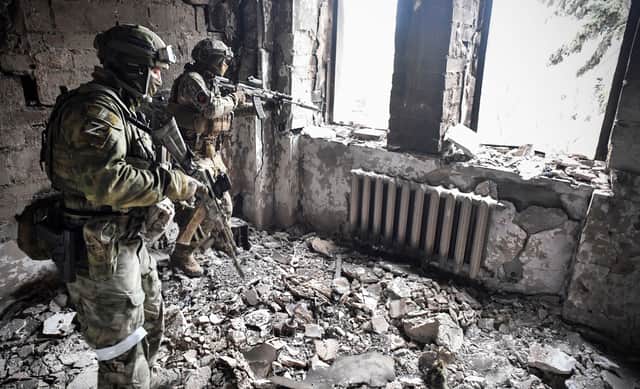 Two Russian soldiers patrol the Mariupol drama theatre, which was hit by a Russian strike in March. (Credit: Getty Images)
