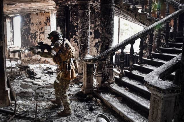 A Russian solder clears patrols a bombed out theatre in the southern Ukrainian city of Mariupol (image: AFP/Getty Images)