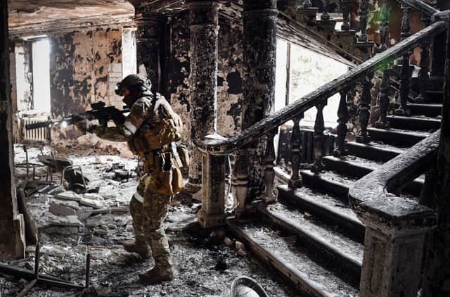 A Russian solder clears patrols a bombed out theatre in the southern Ukrainian city of Mariupol (image: AFP/Getty Images)