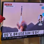 People watch a television screen showing a news broadcast with file footage of a North Korean missile test, at a railway station in Seoul on May 7 (Photo: Getty)