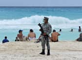 A member of the newly created Tourist Security Battalion of the National Guard stands guard at a beach in Cancun (Photo: AFP via Getty Images)