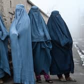 Women wearing a burqa wait to receive free bread distributed as part of the Save Afghans From Hunger campaign in Kabul on January 18, 2022. (Photo by Wakil KOHSAR / AFP)