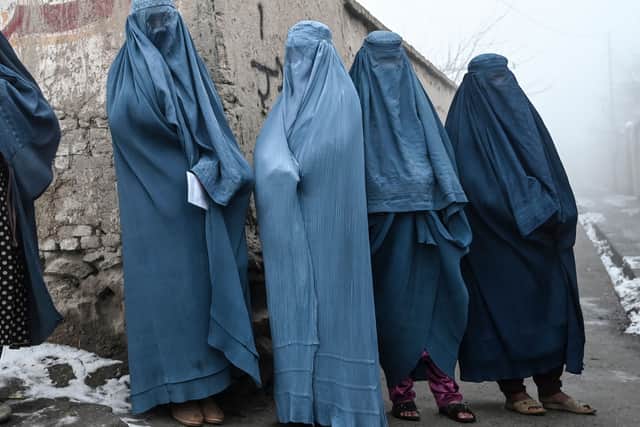 Women wearing a burqa wait to receive free bread distributed as part of the Save Afghans From Hunger campaign in Kabul on January 18, 2022. (Photo by Wakil KOHSAR / AFP)