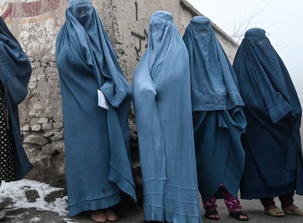 <p>Women wearing a burqa wait to receive free bread distributed as part of the Save Afghans From Hunger campaign in Kabul on January 18, 2022. (Photo by Wakil KOHSAR / AFP)</p>