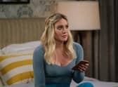 Hilary Duff as Sophie in How I Met Your Father, wearing blue and holding a phone in a hotel bedroom (Credit: Patrick Wymore/Hulu)