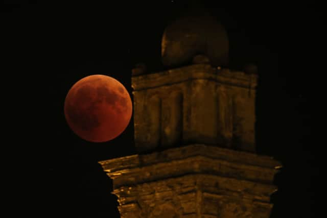 A picture shows the full moon during a “blood moon” eclipse beside the church of Venzolasca, on the French Mediterranean island of Corsica, on July 27, 2018 (Photo by PASCAL POCHARD-CASABIANCA/AFP via Getty Images)