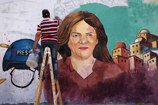 Palestinian artists paint a mural in honour of Al Jazeera journalist Shireen Abu Akleh (Pic: Getty Images)