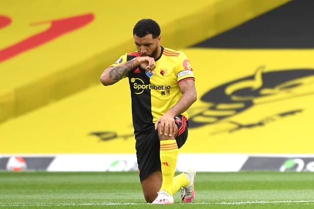 Troy Deeney takes a knee before a Watford versus Norwich City match in 2020