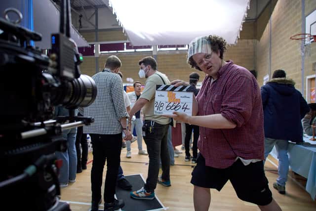 Jack Rooke behind the scenes of Big Boys, holding a clapperboard (Credit: Channel 4)
