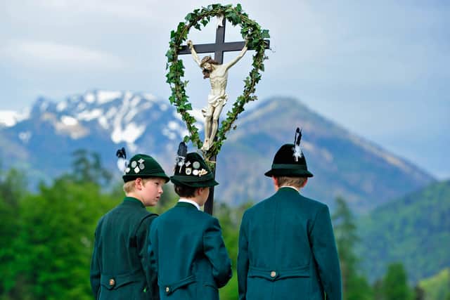 Three boys wearing Bavarian folk costumes specific to the Chiemsee region of southern Bavaria carry a cross during the annual Ascension Day procession on May 9, 2013 
