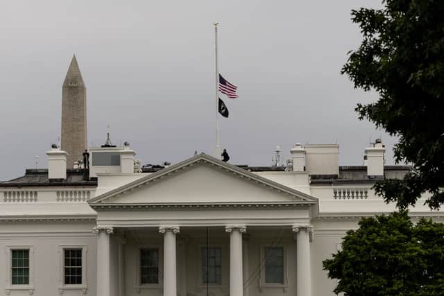 A U.S. Secret Service officer lowers the American flag to half staff over the White House following the recent mass shooting at a Texas elementary school (Photo by Anna Moneymaker/Getty Images)