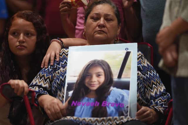 A woman holds a photo of Nevaeh Bravo, who was killed in the mass shooting,