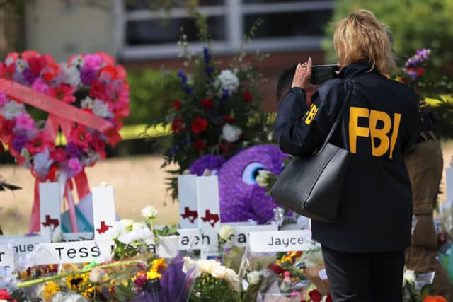 An FBI agent takes a photo of a memorial for victims of Tuesday’s mass shooting at Robb Elementary School on May 27, 2022 in Uvalde, Texas (Photo by Michael M. Santiago/Getty Images)