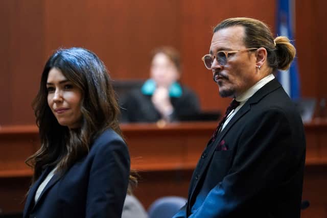US actor Johnny Depp stands next to his lawyer Camille Vasquez after a break in the defamation trial against ex-wife Amber Heard (Photo by KEVIN LAMARQUE/POOL/AFP via Getty Images)