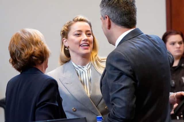 Actor Amber Heard talks with her legal team including Elaine Bredehoft, left, and Benjamin Rottenborn, right, in the courtroom at the Fairfax County Circuit Courthouse (Photo by STEVE HELBER/POOL/AFP via Getty Images)
