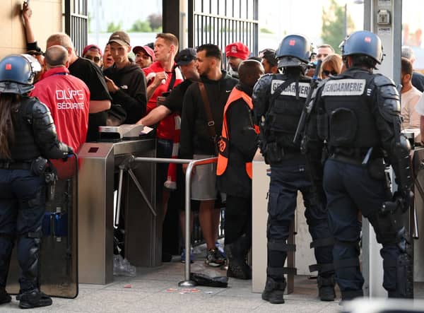 Police and stewards are seen outside the stadium as Liverpool fans queue outside the stadium prior to  the UEFA Champions League final (Photo by Matthias Hangst/Getty Images)