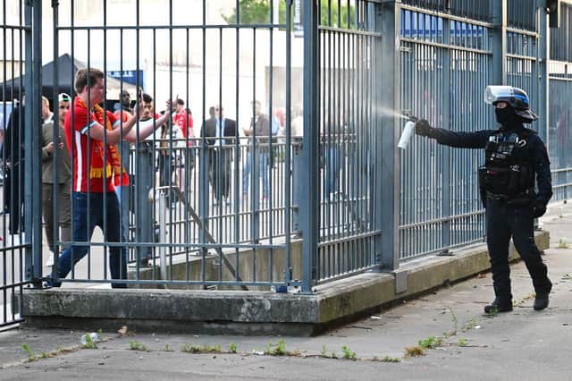 Police spray tear gas at Liverpool fans outside the stadium as they queue prior to the UEFA Champions League final match between Liverpool FC and Real Madrid at Stade de France on May 28, 2022 in Paris, France (Photo by Matthias Hangst/Getty Images)