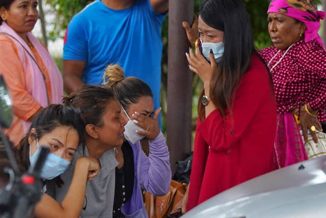 Family members and relatives of passengers on board the Twin Otter aircraft operated by Tara Air, weep outside the airport in Pokhara on May 29, 2022 (Photo by YUNISH GURUNG/AFP via Getty Images)