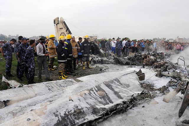 Nepalese fireman and volunteers look over the wreckage of a Sita airplane after it crashed, killing all 19 people on board (Photo: BIKASH KARKI/AFP/GettyImages)