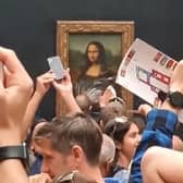 A man dressed as an elderly woman shocked visitors to the Louvre after smearing cake on the Mona Lisa. (Credit: PA)