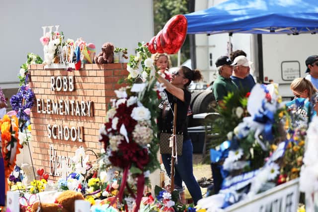 People visit a memorial for the victims of the Robb Elementary School shooting (Photo by Michael M. Santiago/Getty Images)