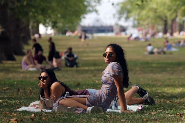 People enjoy the warm weather in Green Park, London (Photo by ISABEL INFANTES/AFP via Getty Images)