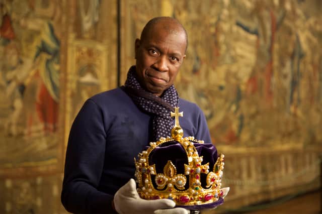 Clive Myrie holding Henrys Crown, a replica of Henry VIIIs original crown in the Great Hall of Hampton Court Palace (Credit: BBC/The Royal Collection Trust)