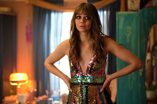 Emma Appleton as Maggie, her makeup smudged, wearing a sparkly rainbow dress (Credit: BBC / Working Title / Universal International Studios Limited)