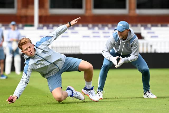 Ollie Pope dives for a ball in training as Joe Root looks on