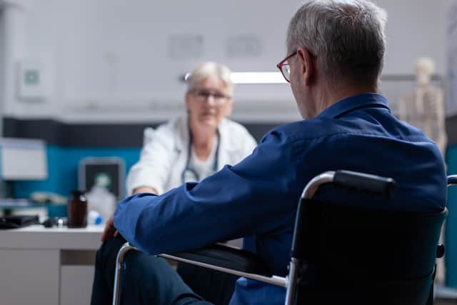 Close up of patient sitting in wheelchair at healthcare consultation with physician in cabinet (Credit DC Studio - stock.adobe.com)