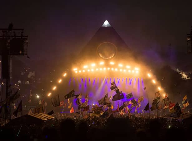 <p>Revellers watch the Pyramid Stage at the Glastonbury Festival on June 29, 2019 (Photo by OLI SCARFF/AFP via Getty Images)</p>