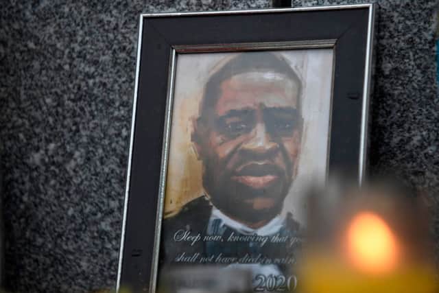 A candle burns in front of a the drawn portrait of George Floyd in Denver, Colorado on June 6, 2020, during a protest over his death in police custody