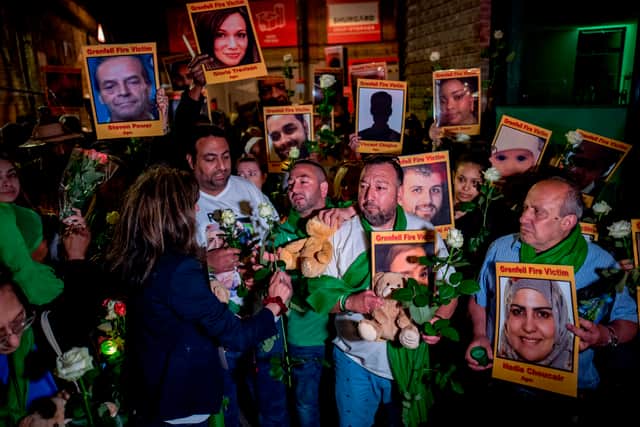 Families and friends who lost loved ones in the Grenfell Tower fire hold portraits of victims as they march to Grenfell Tower in west London at midnight June 14, 2018 .