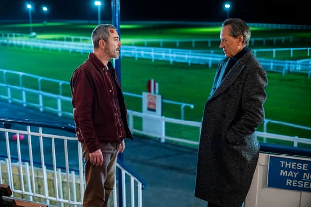 James Nesbitt as Danny and Richard E Grant as Harry, stood in the grounds of a horse racing stadium (Credit: Laurence Cendrowicz/Channel 4)