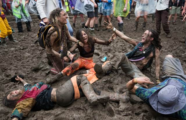 Festival revellers roll in the mud at the Glastonbury Festival in 2016 (Pic: Getty Images)