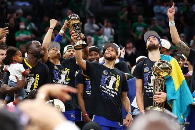 Step Curry of the Golden State Warriors raises the Bill Russell NBA Finals Most Valuable Player Award after defeating the Boston Celtics 103-90 in Game Six of the 2022 NBA Finals (Photo by Elsa/Getty Images)
