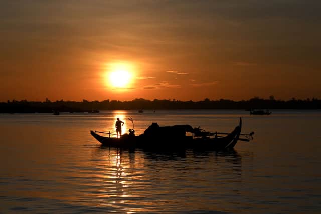 A fisherman sorts out a net on a fishing boat in the Mekong River in Phnom Penh, Cambodia (Pic: AFP via Getty Images)