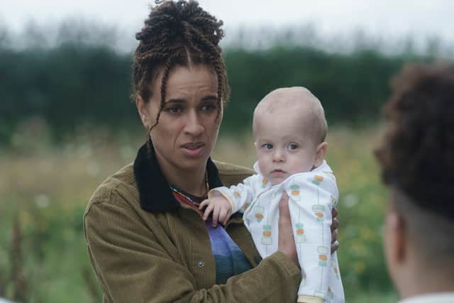 Michelle De Swarte as Natasha, looking exhausted and holding a spooky looking baby (Credit: Ross Ferguson/Sky/HBO)