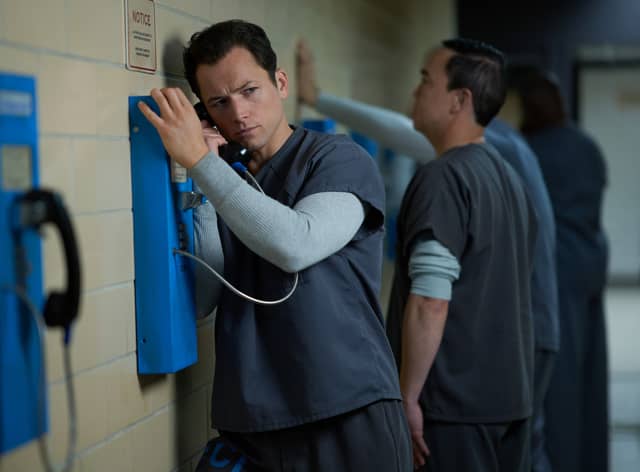 Taron Egerton as Jimmy Keene in Black Bird, using a prison payphone (Credit: Apple TV+)