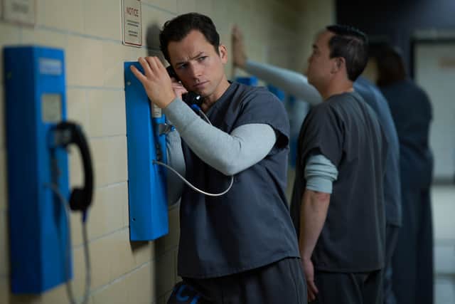 Taron Egerton as Jimmy Keene in Black Bird, using a prison payphone (Credit: Apple TV+)
