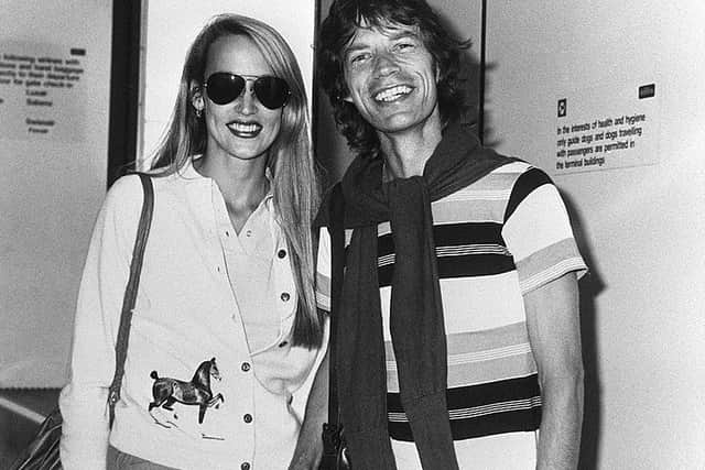 Rolling Stones singer Mick Jagger poses with his girlfriend, fashion model Jerry Hall, 13 August 1981 at their arrival from Paris at Heathrow airport (Photo by AFP/AFP via Getty Images)