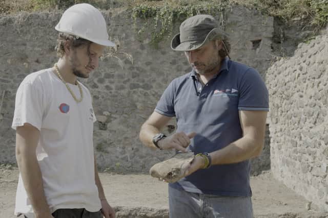 Archaeology student Dario Lo Surdo and Archaeologist Mario Grimaldi investigate an oxen skull found beneath a street in Pompeii