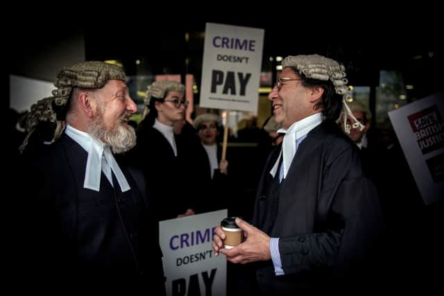Criminal barristers from the Criminal Bar Association (CBA), which represents barristers in England and Wales, outside Manchester Crown Court on the first of several days of court walkouts .